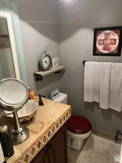 Bathroom featuring a vessel sink set into a tiled countertop with a dark wood vanity