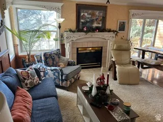 Living area featuring a fireplace with a tile surround and decorative mantelpiece, large window, and sliding glass door