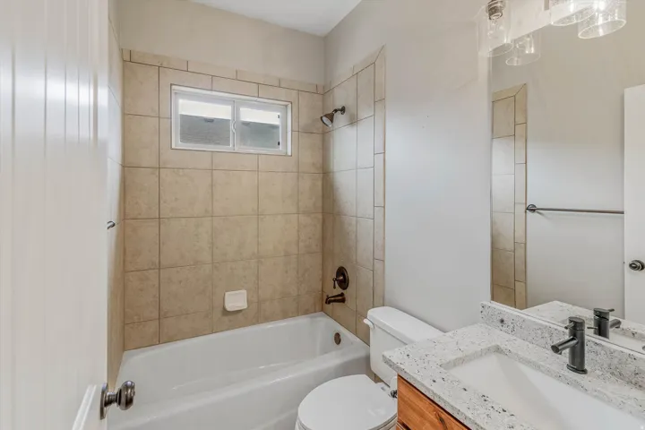 Bathroom featuring a tiled tub/shower combination with a frosted window