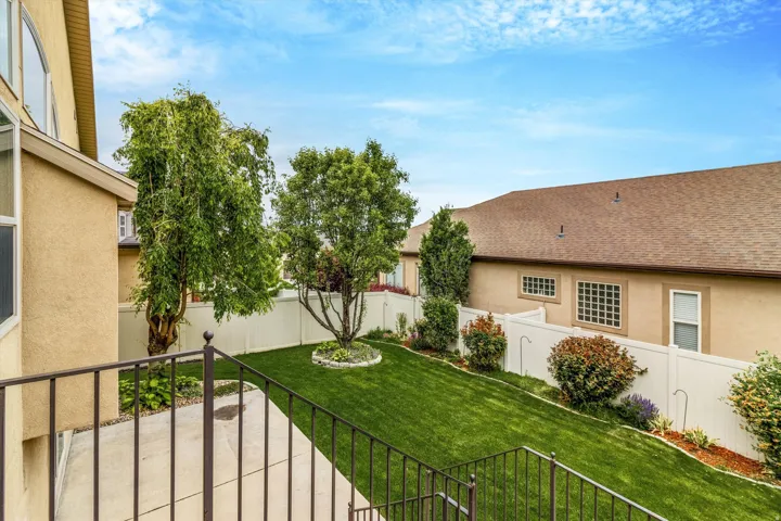 Expansive outdoor space featuring a sloped lawn, mature trees, and shrubs