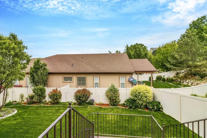 Expansive backyard featuring a manicured lawn, established landscaping, and privacy fencing