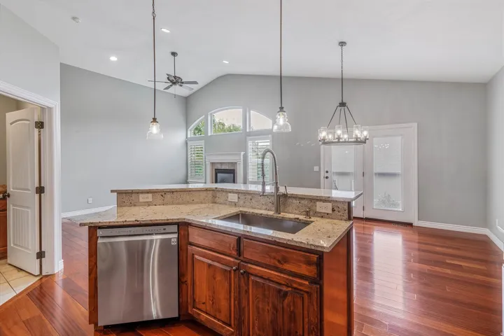 Kitchen island with granite countertops, stainless steel sink, and gooseneck faucet