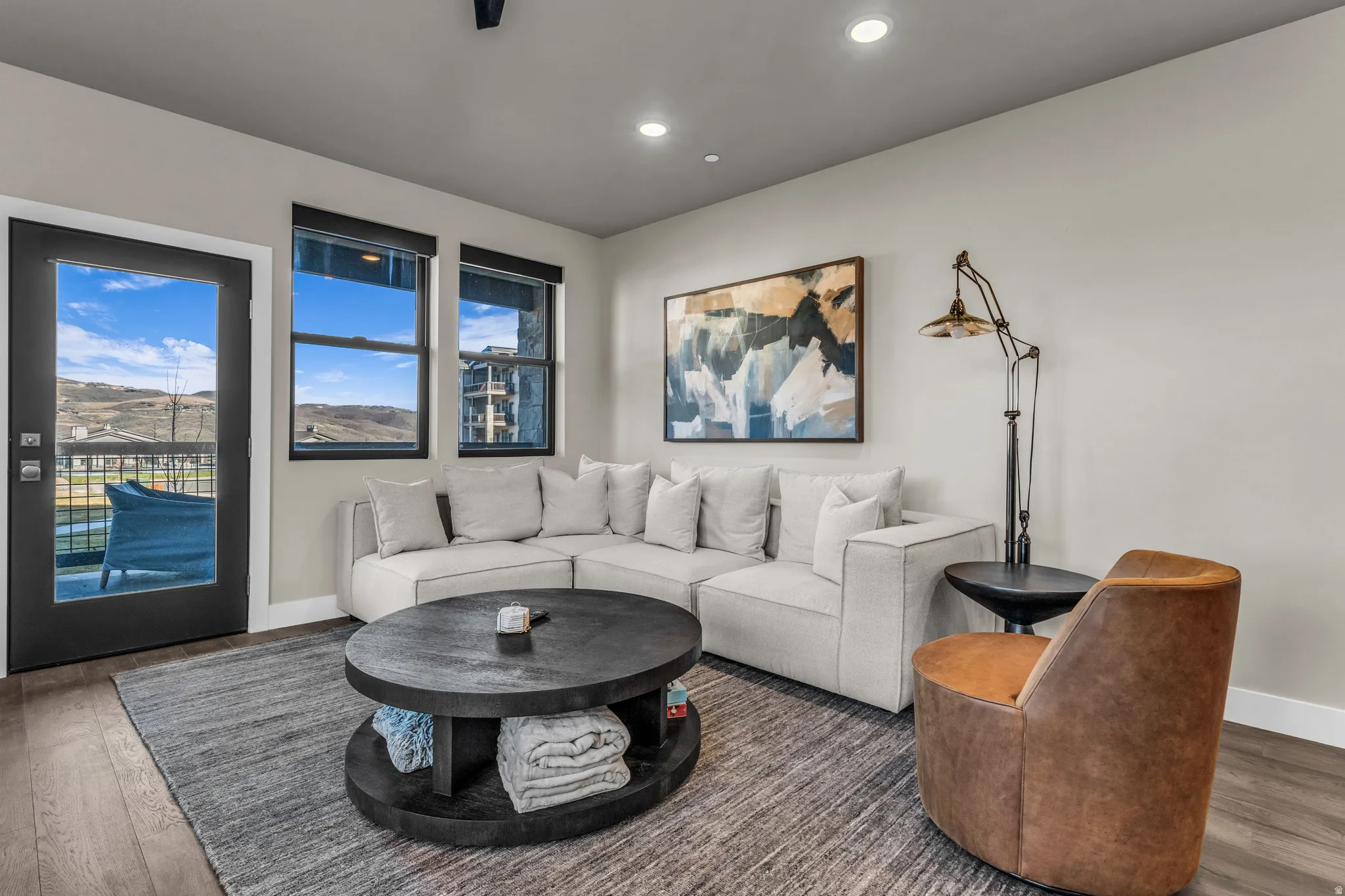 Living area featuring wood-finish flooring, light neutral wall paint, and recessed ceiling lighting