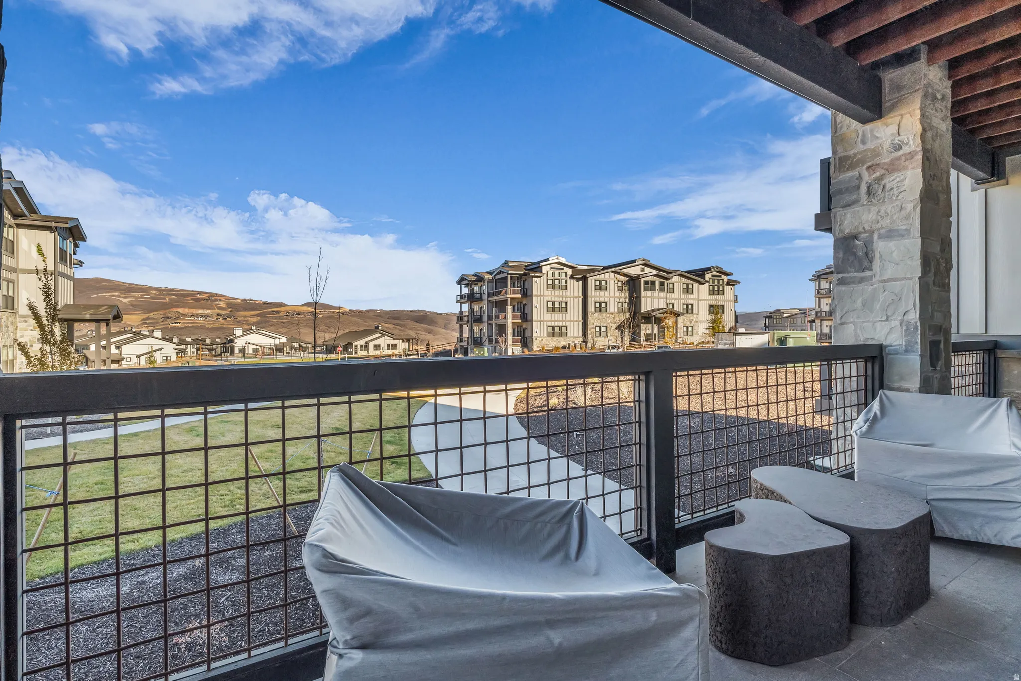 Private patio with stone flooring and a metal grid railing
