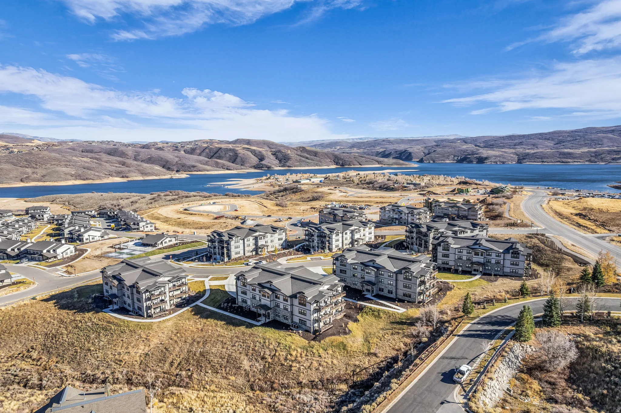 Expansive hillside community featuring multi-story residential buildings with dark roofs and light-toned siding