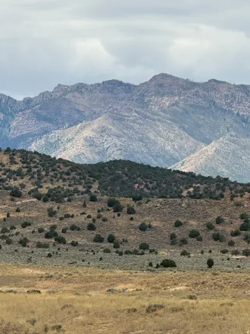Expansive natural landscape featuring rolling hills and distant mountainous terrain