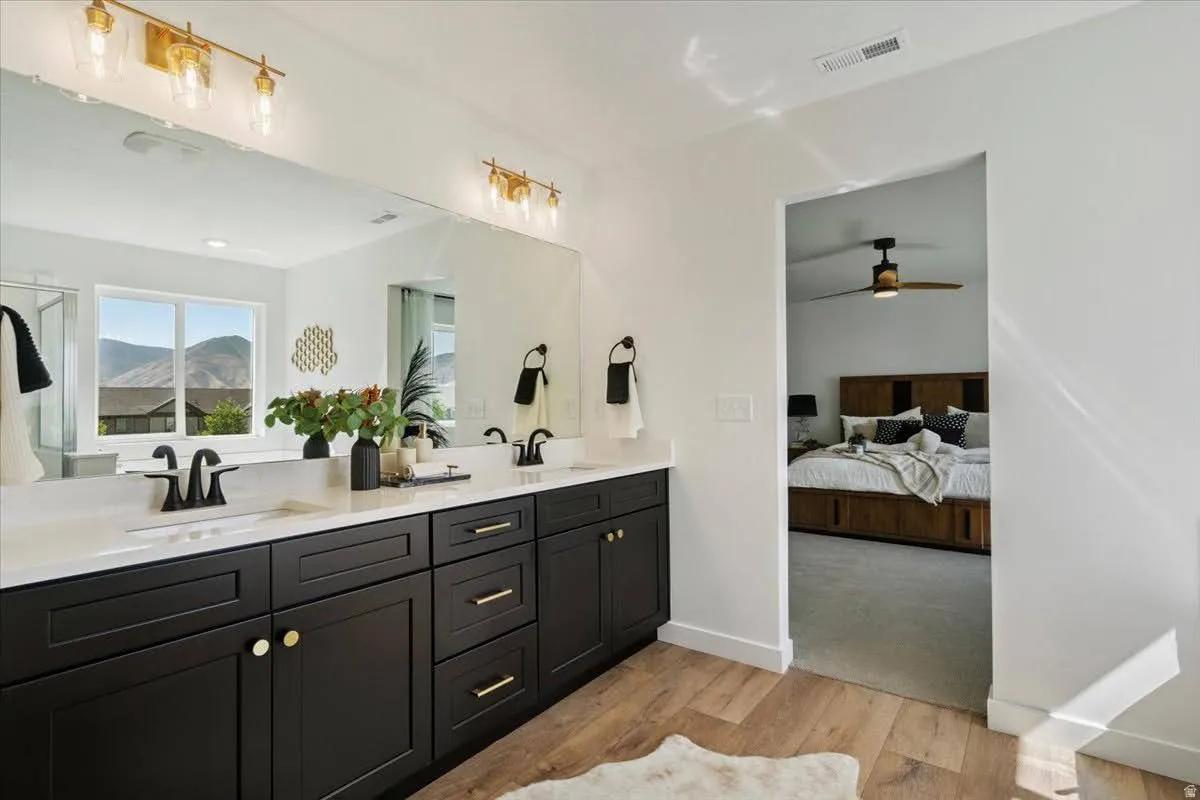 Double vanity with dark cabinetry, white countertops, and matte black fixtures