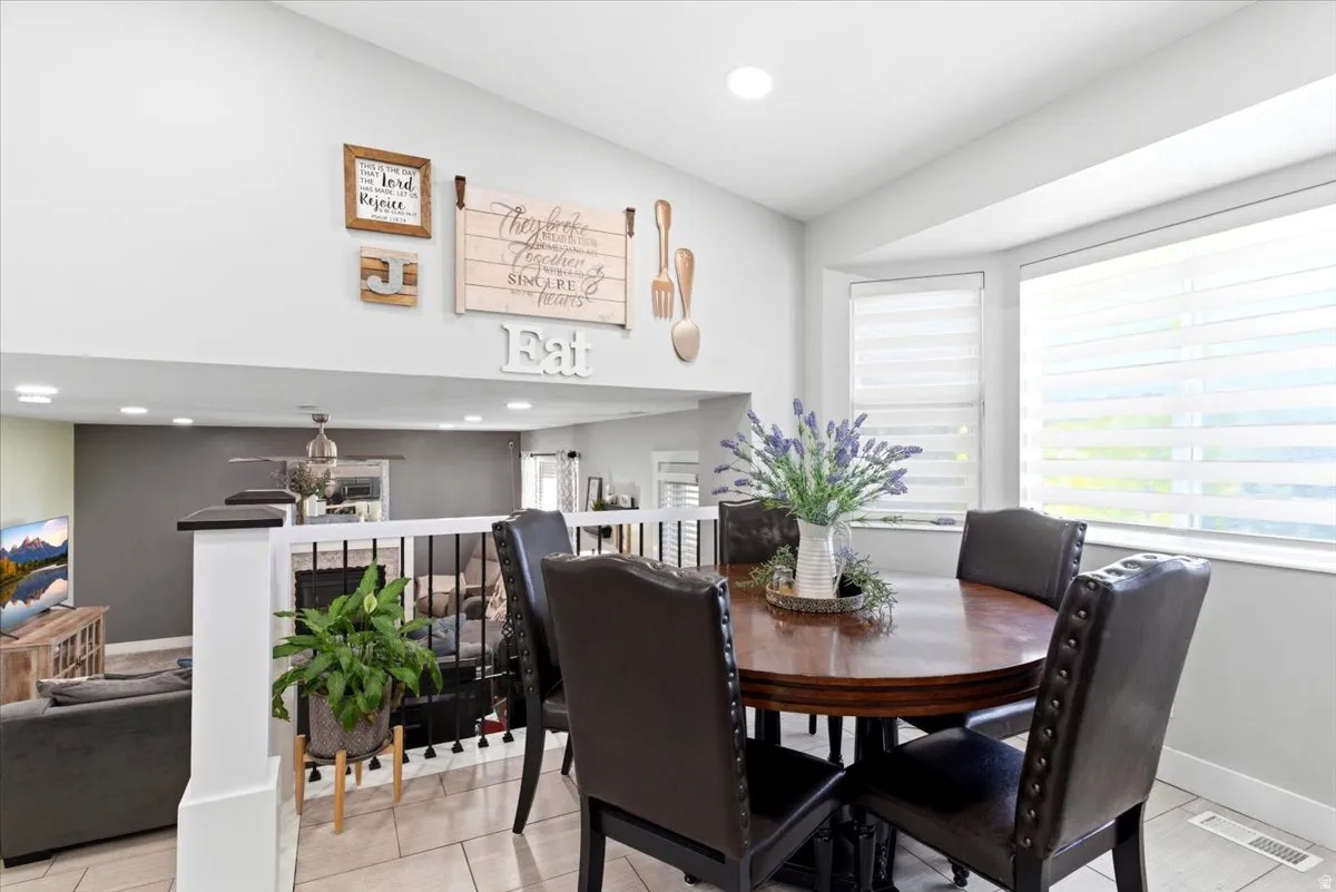 Open-concept dining area featuring a bay window, tile flooring, and recessed lighting