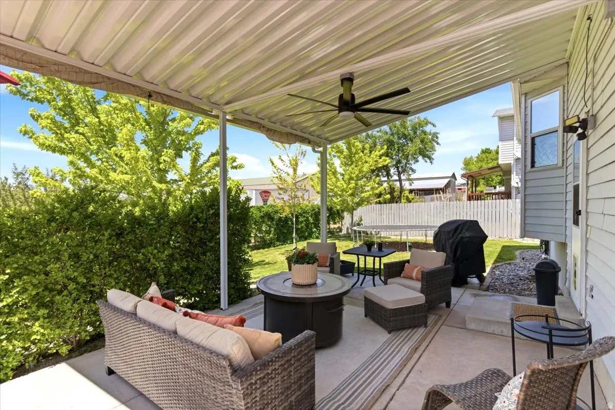 Expansive covered patio featuring a ceiling fan, concrete flooring, and direct access to a fenced yard