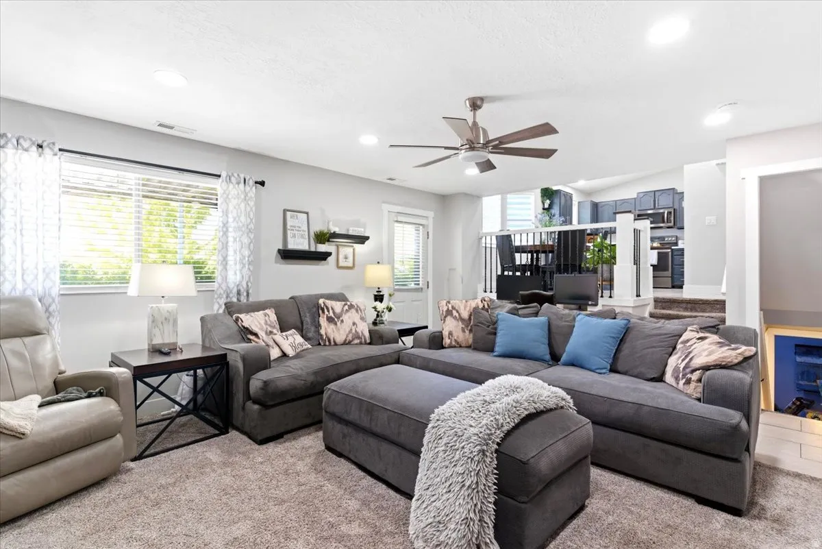 Spacious living area featuring carpet flooring, recessed lighting, and a ceiling fan