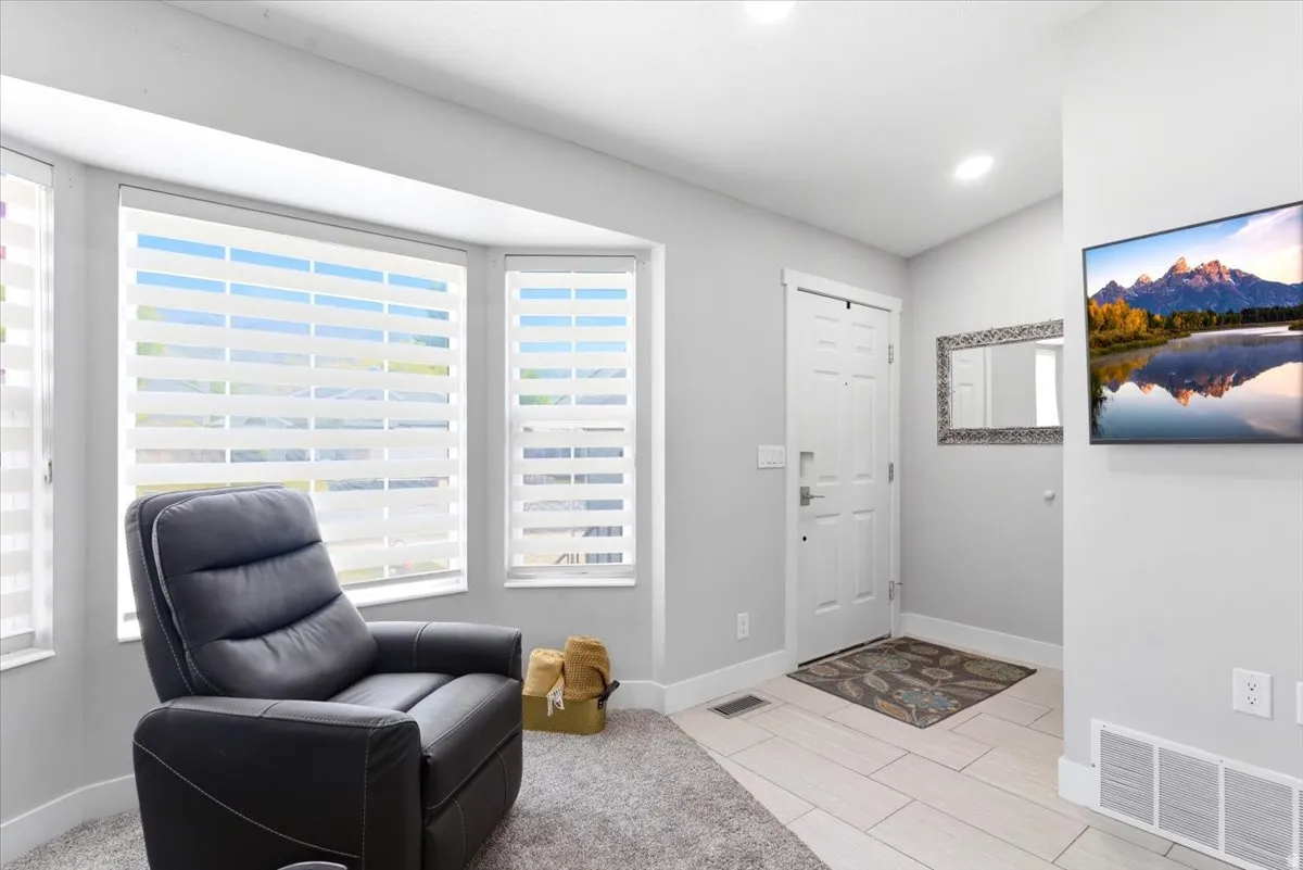 Bright entry area with a bay window featuring layered window treatments