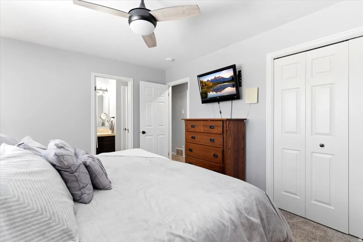 Neutral wall color with a ceiling fan featuring wood-finish blades