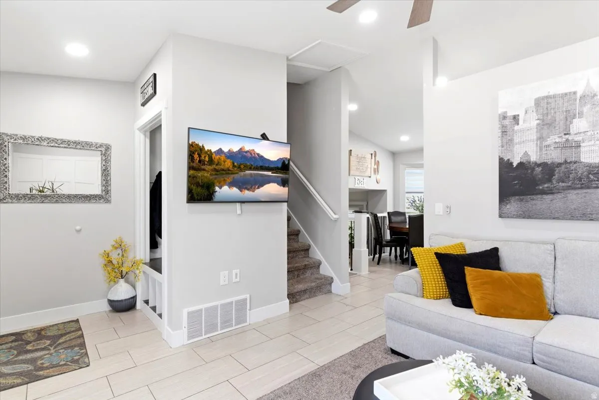 Open living space featuring light-toned tile flooring and recessed lighting