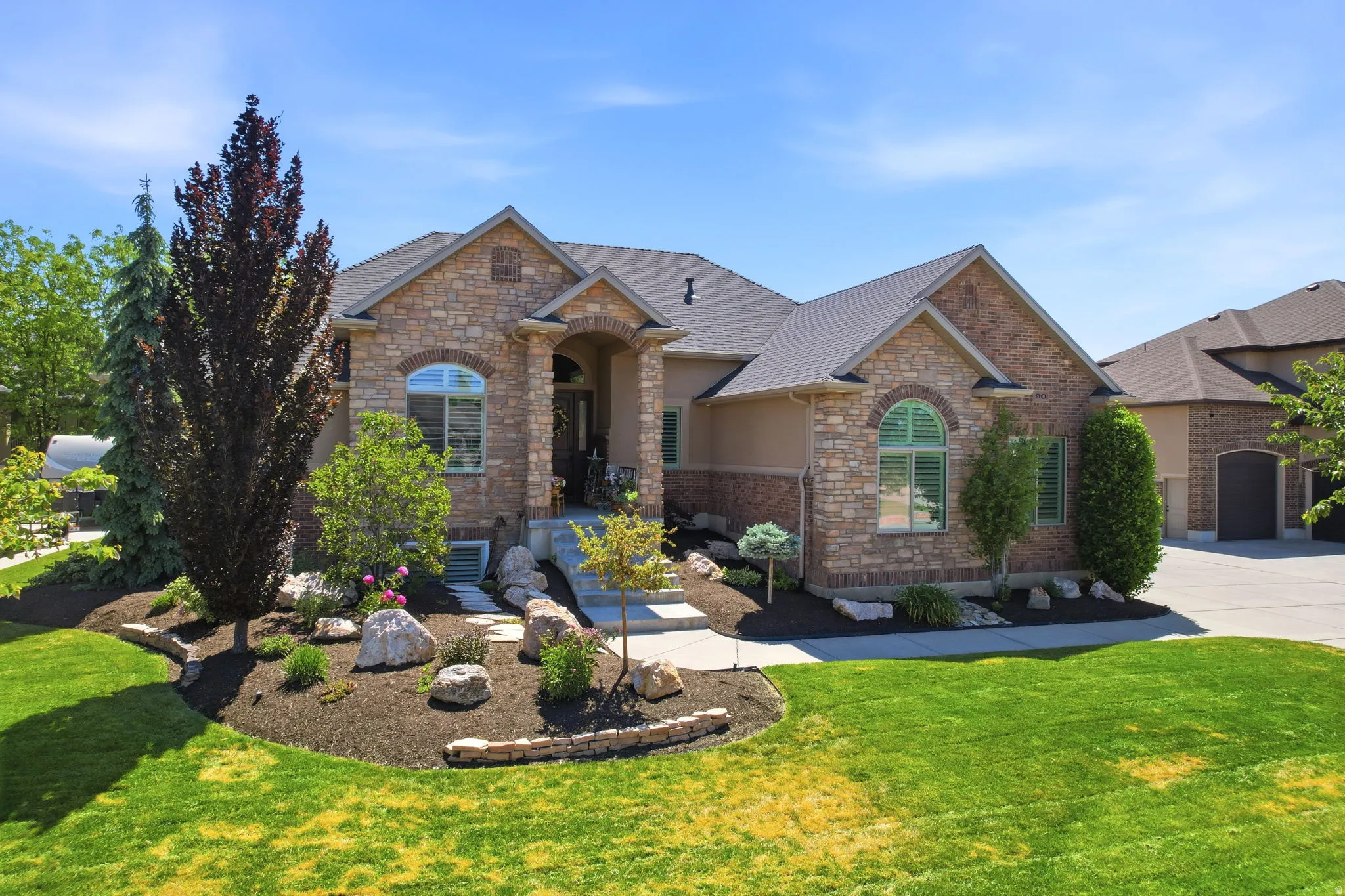 Stone and stucco exterior with an arched entry