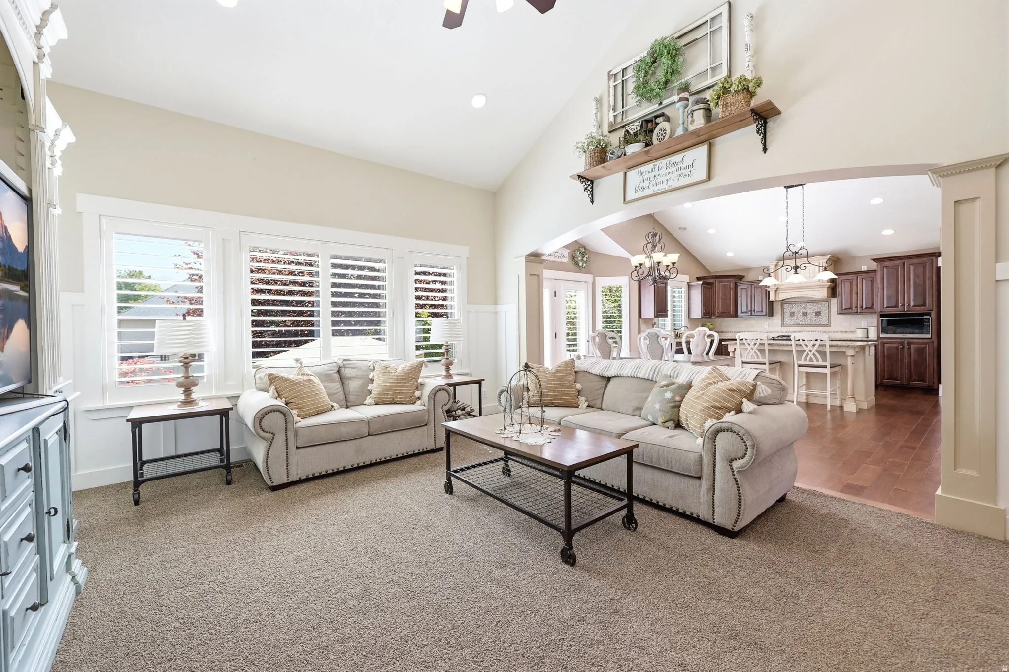 Spacious living area featuring vaulted ceilings, recessed lighting, and a neutral color palette