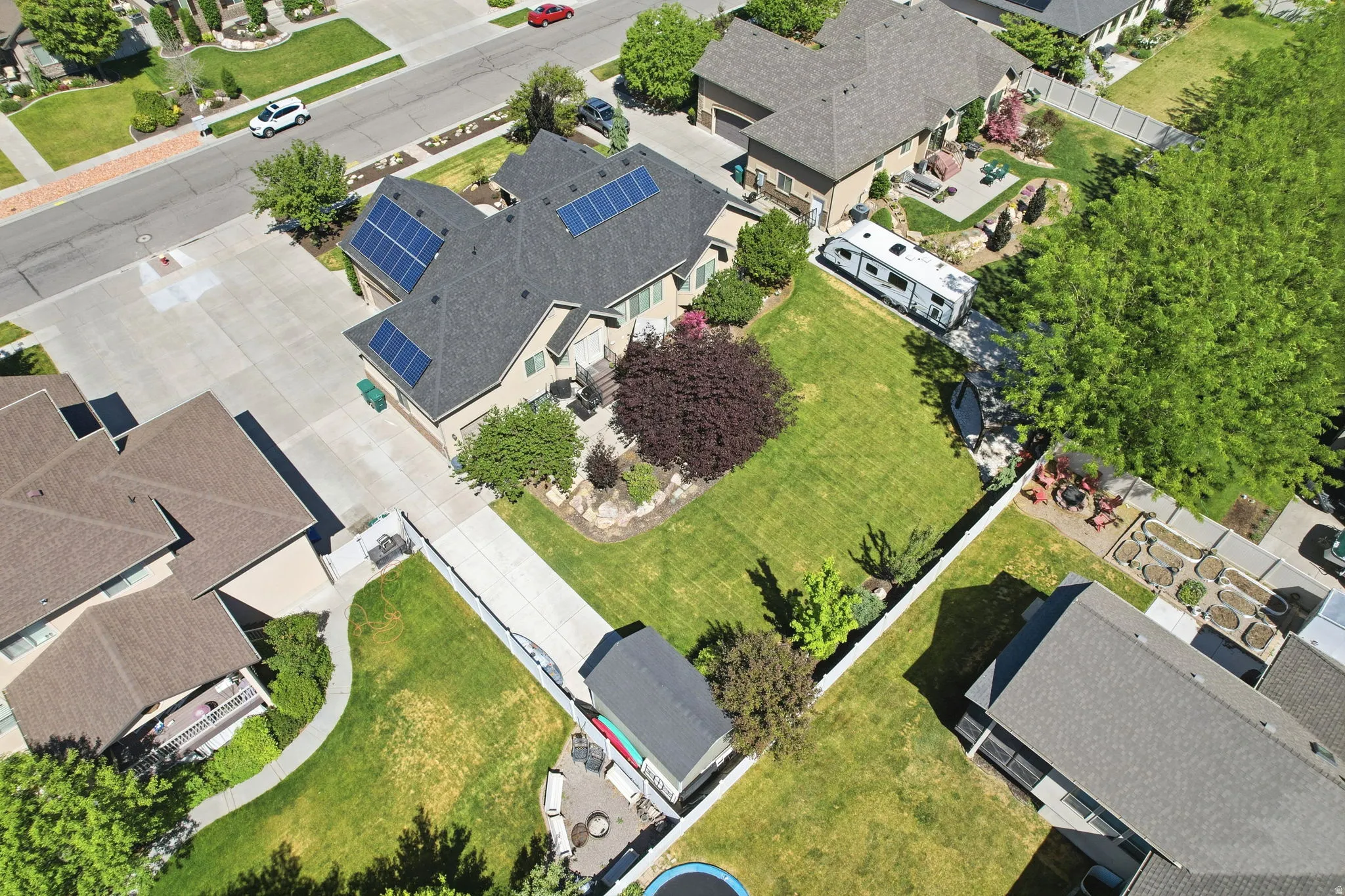Aerial property overview featuring a two-story residence with a gray shingled roof and multiple solar panels