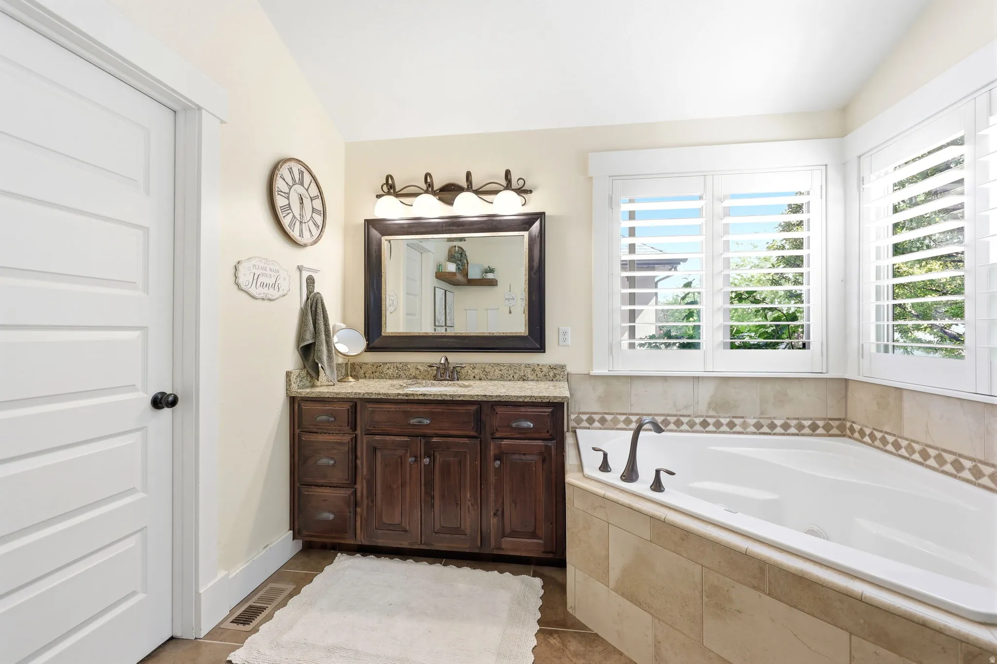 Soaking tub featuring tile surround with decorative accent border