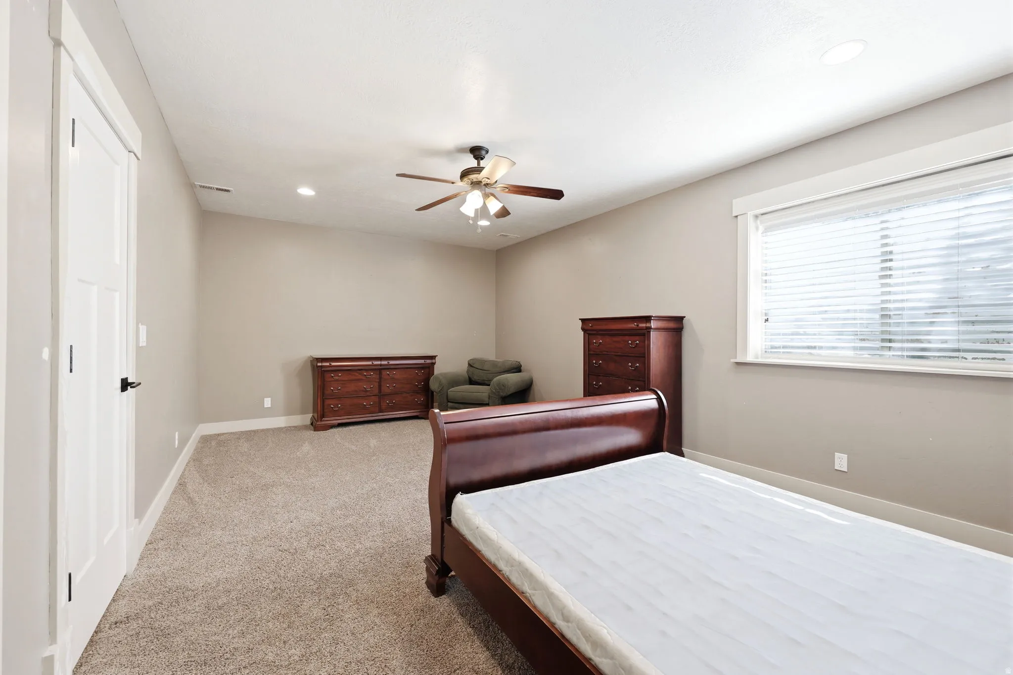 Carpeted room featuring a ceiling fan with light, recessed lighting, and a window with blinds