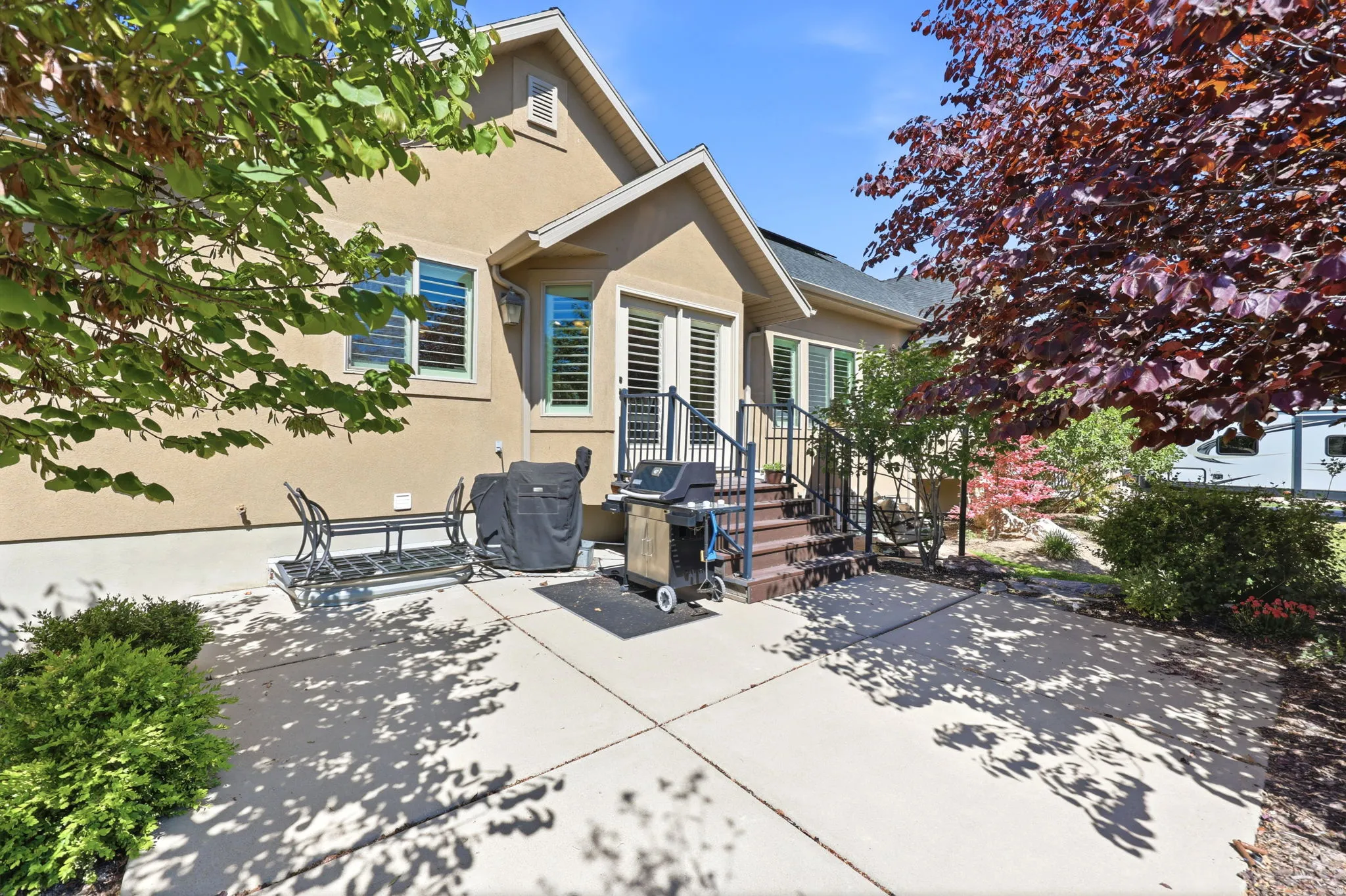 Expansive concrete patio offering direct outdoor access through double French doors