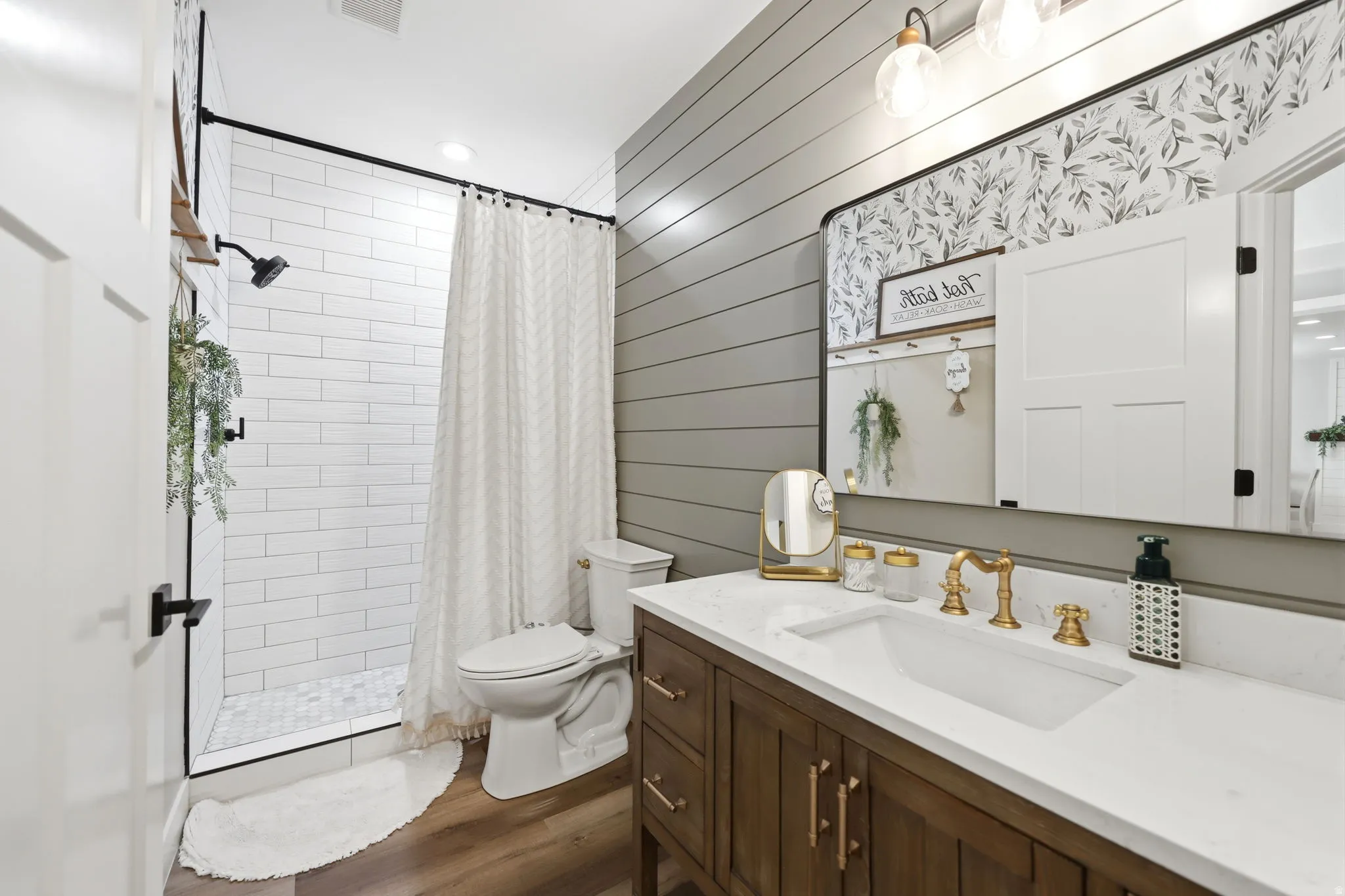Bathroom featuring a wood-finish vanity with a white countertop and integrated rectangular sink