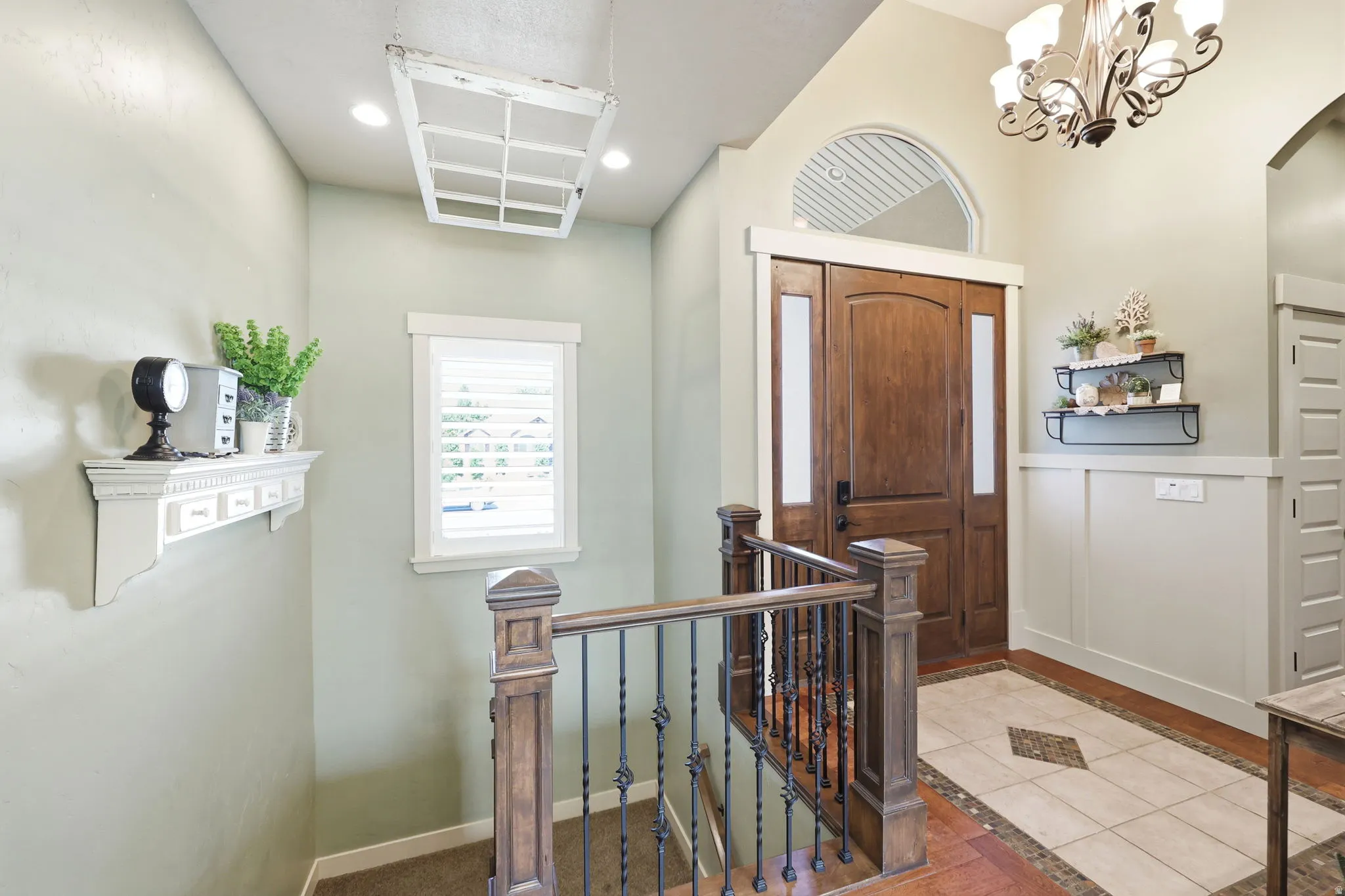 Foyer with a dark wood entry door featuring side lites and an arched transom window