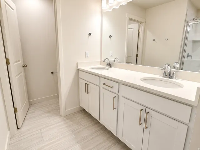 Primary bathroom with 2 sinks and a large walk in shower.