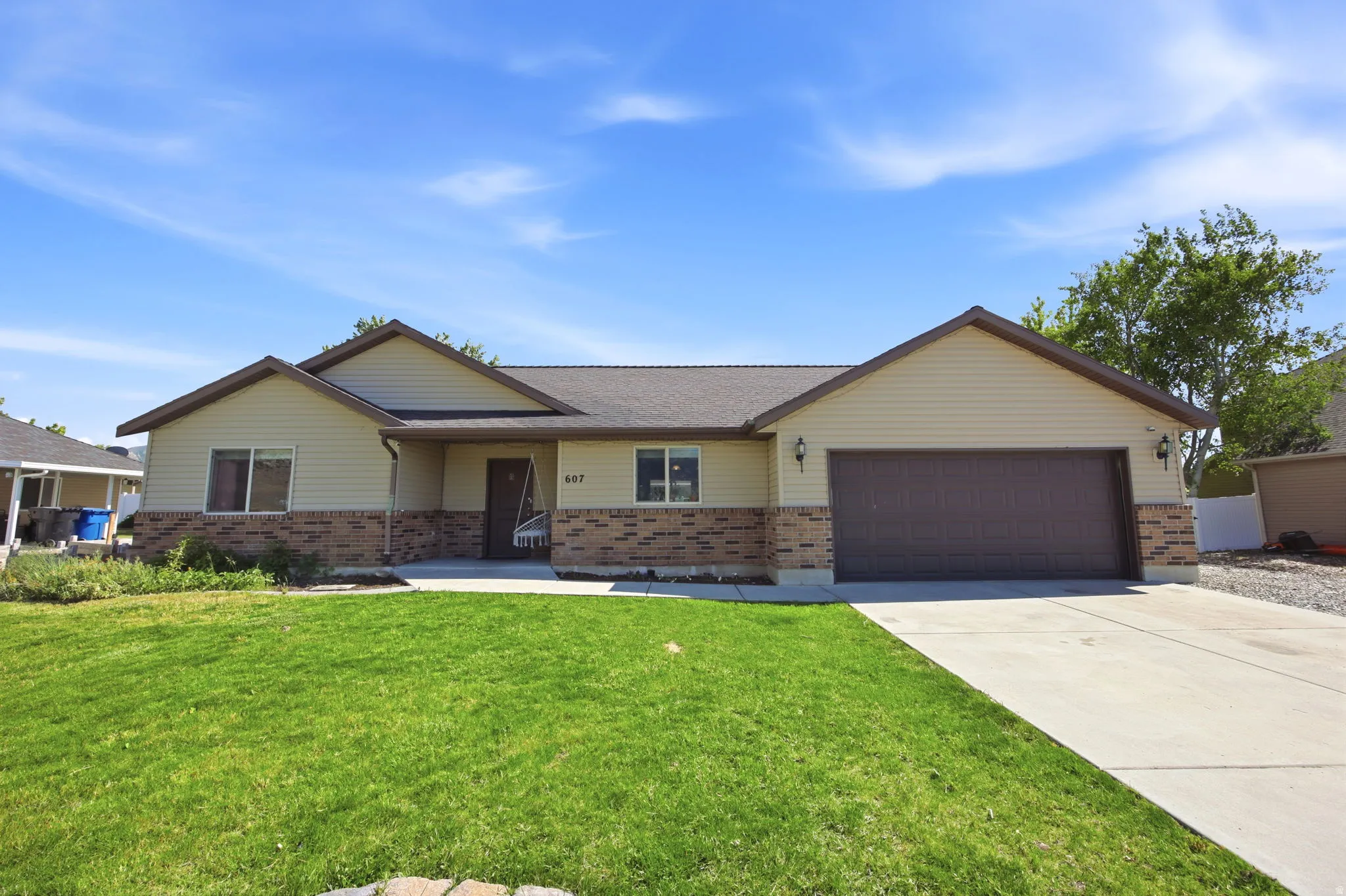 Ranch-style exterior featuring light-colored siding and brick accents
