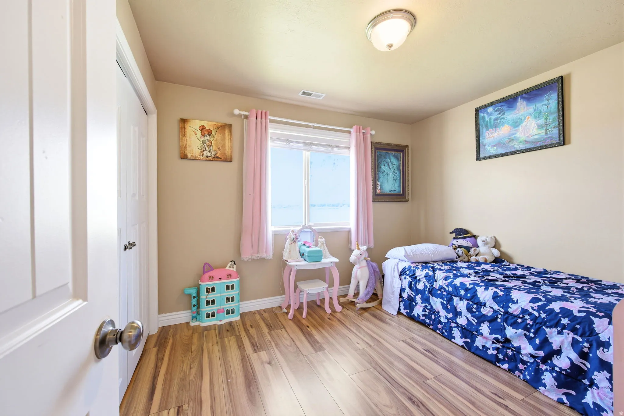 Bedroom featuring wood-finish flooring, a window with natural light, and a flush mount ceiling light fixture