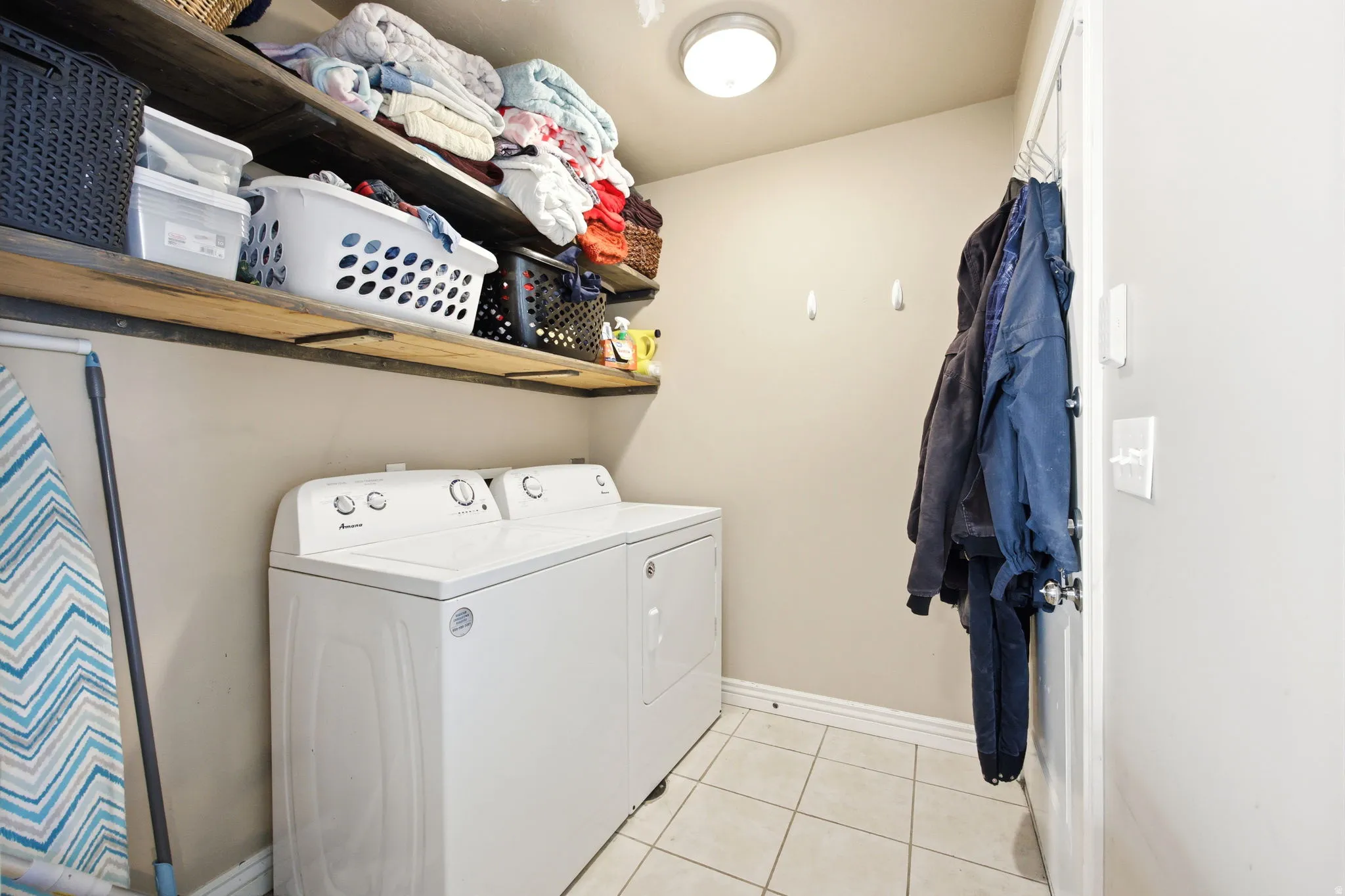 Utility space featuring white floor tiles and a ceiling-mounted light fixture