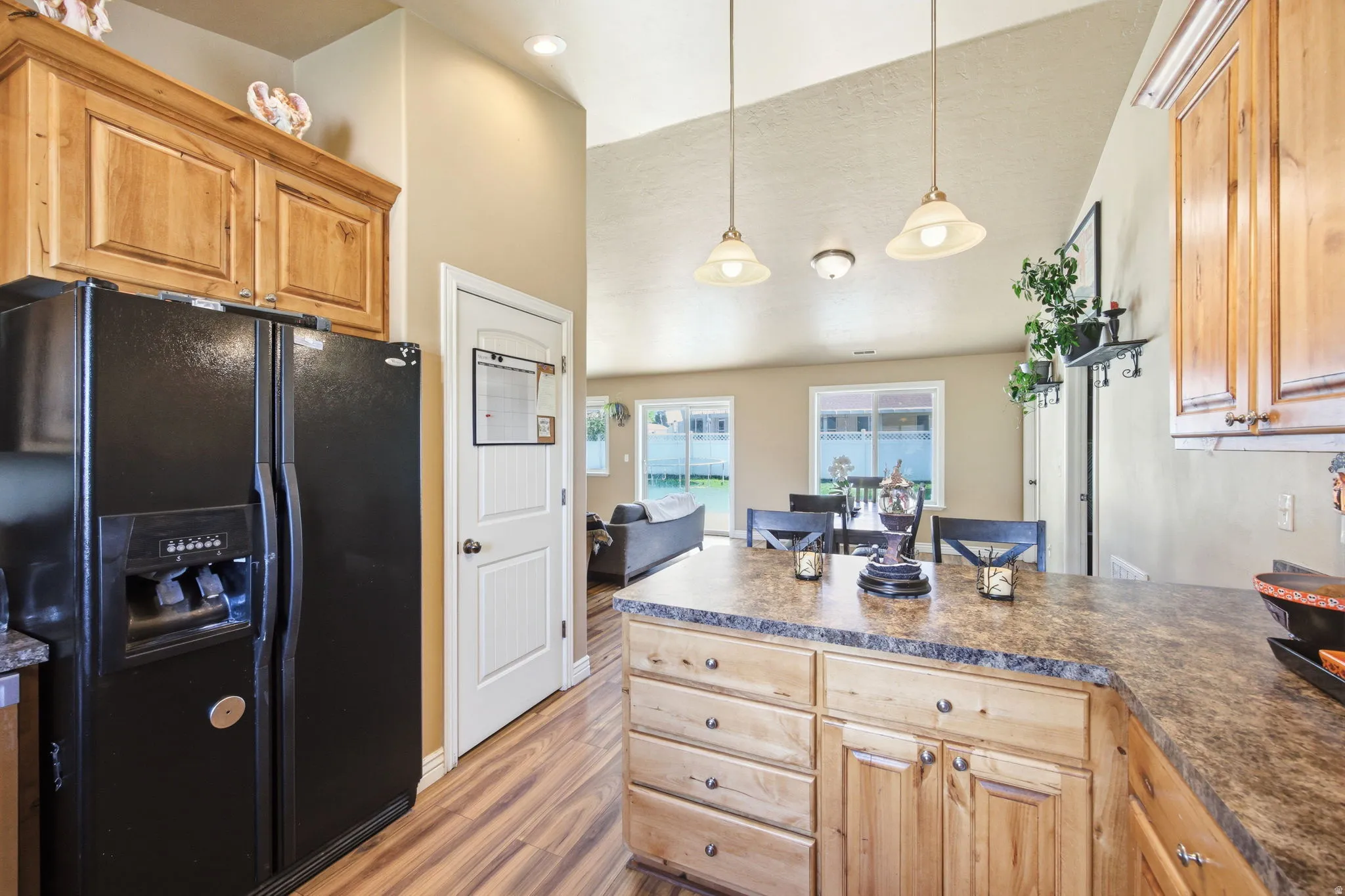 Kitchen featuring wood-finish flooring, natural wood cabinetry, and speckled countertops