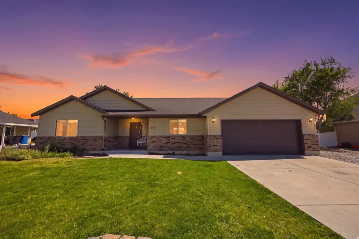 Ranch-style residence featuring a brick and siding exterior, an attached two-car garage, a concrete driveway, and a covered front porch
