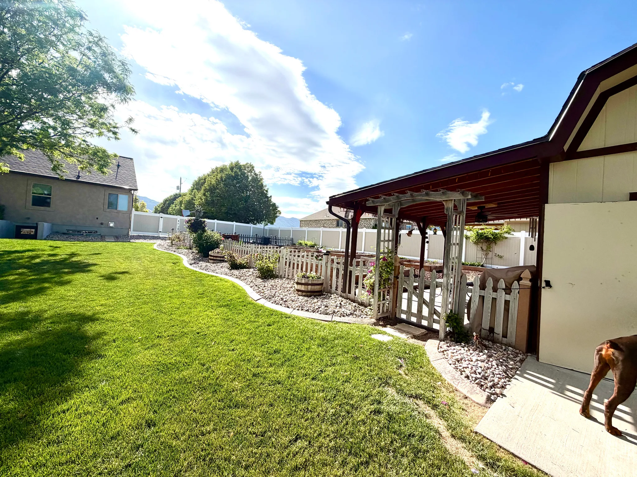 Expansive grassy yard area with a rock-edged garden bed