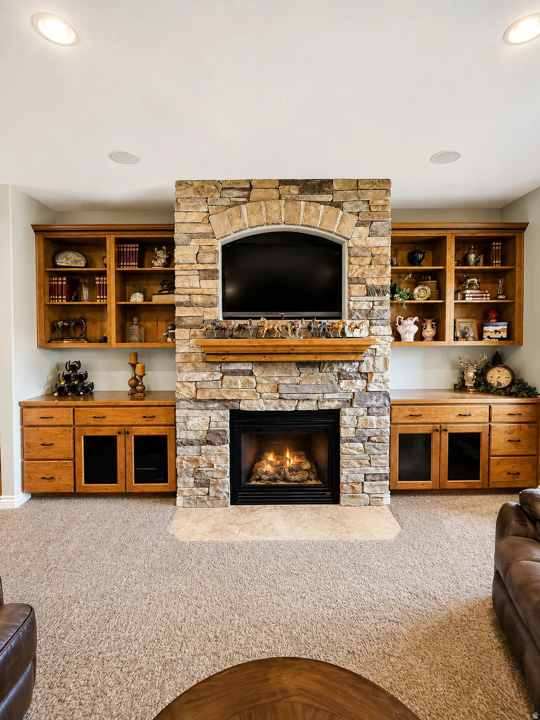Central stone fireplace with an arched television recess and a wood mantel