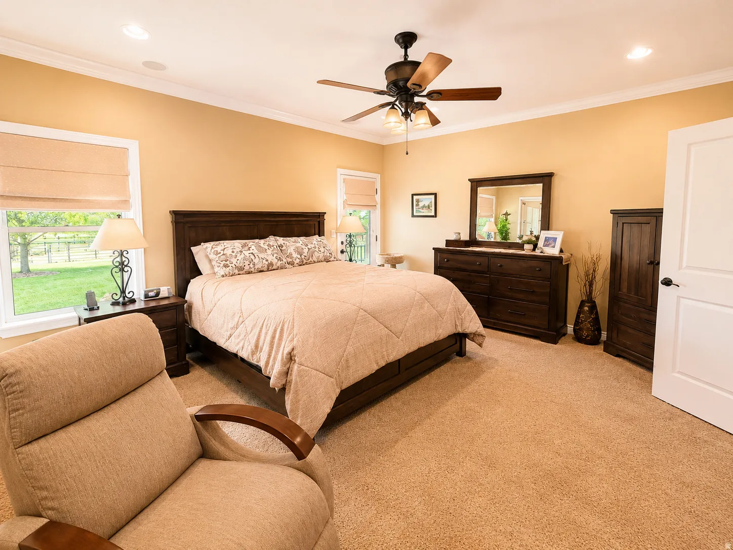 Carpeted room featuring a large window with Roman shades, crown molding, recessed lighting, and a ceiling fan