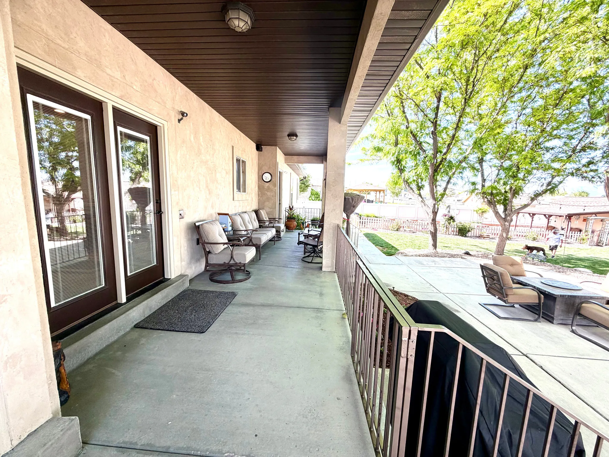 Covered patio featuring textured stucco exterior walls and a brown paneled ceiling