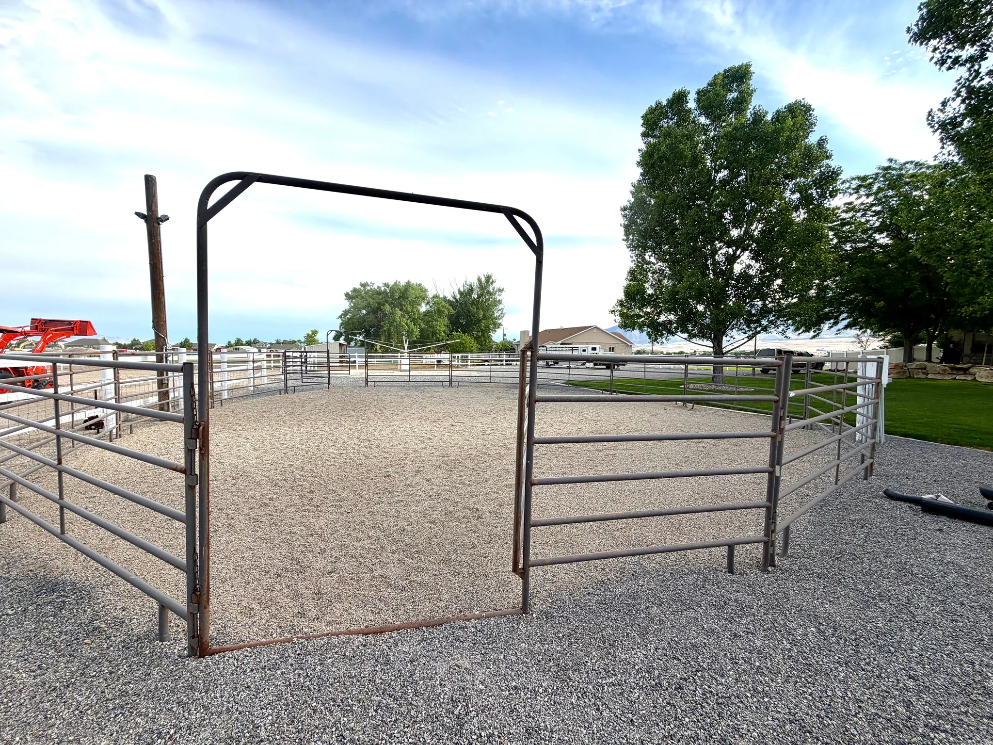 Enclosed round pen with a sand base, surrounded by metal fencing