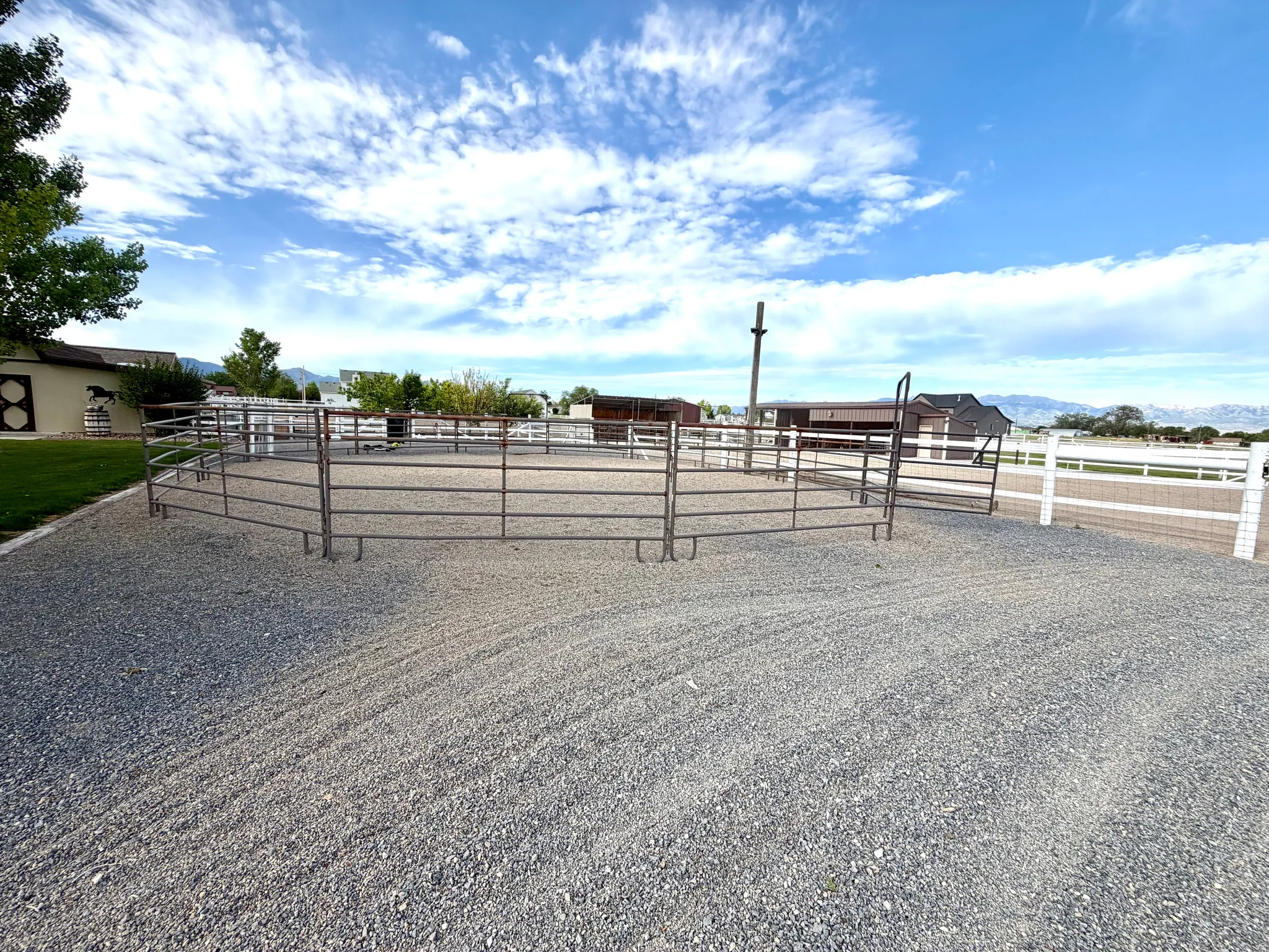Expansive gravel outdoor arena with metal panel fencing