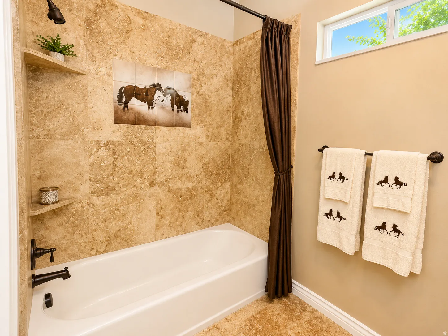Tub and shower combination featuring earth-toned wall tile and a built-in shower niche with shelving