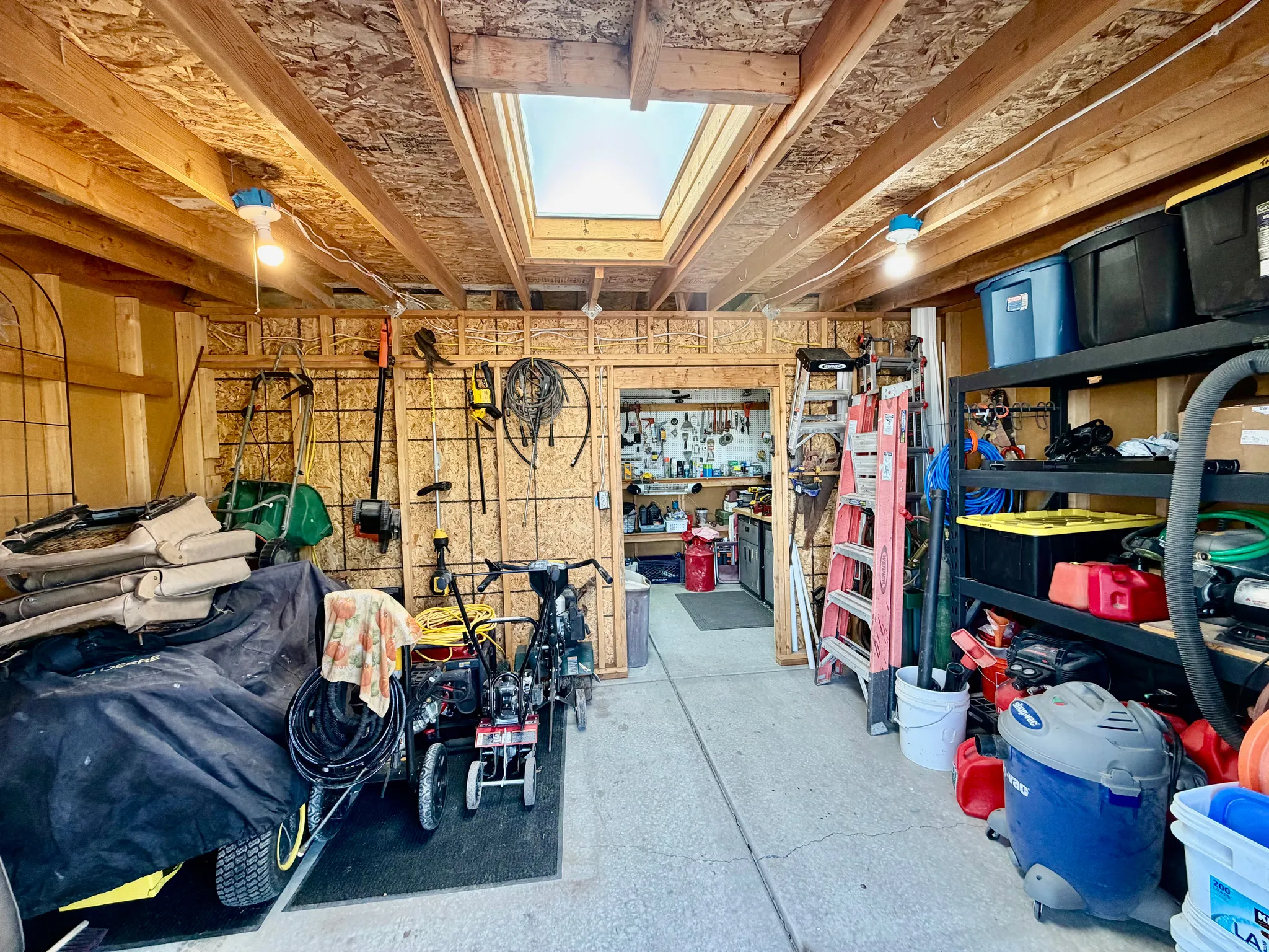 Utility space featuring exposed wood framing, a large skylight, and multiple light fixtures