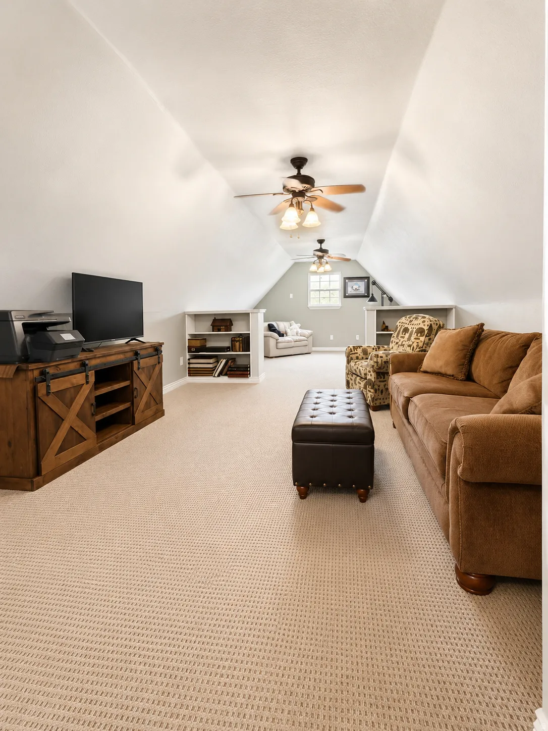 Spacious attic room with sloped ceilings and light beige carpeting
