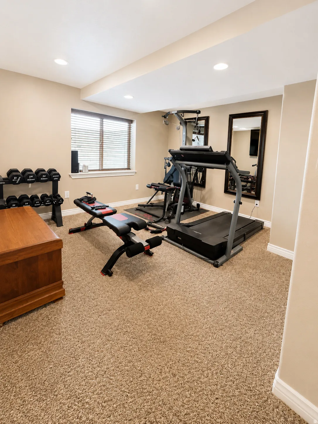 Carpeted room with recessed lighting and a window featuring horizontal blinds