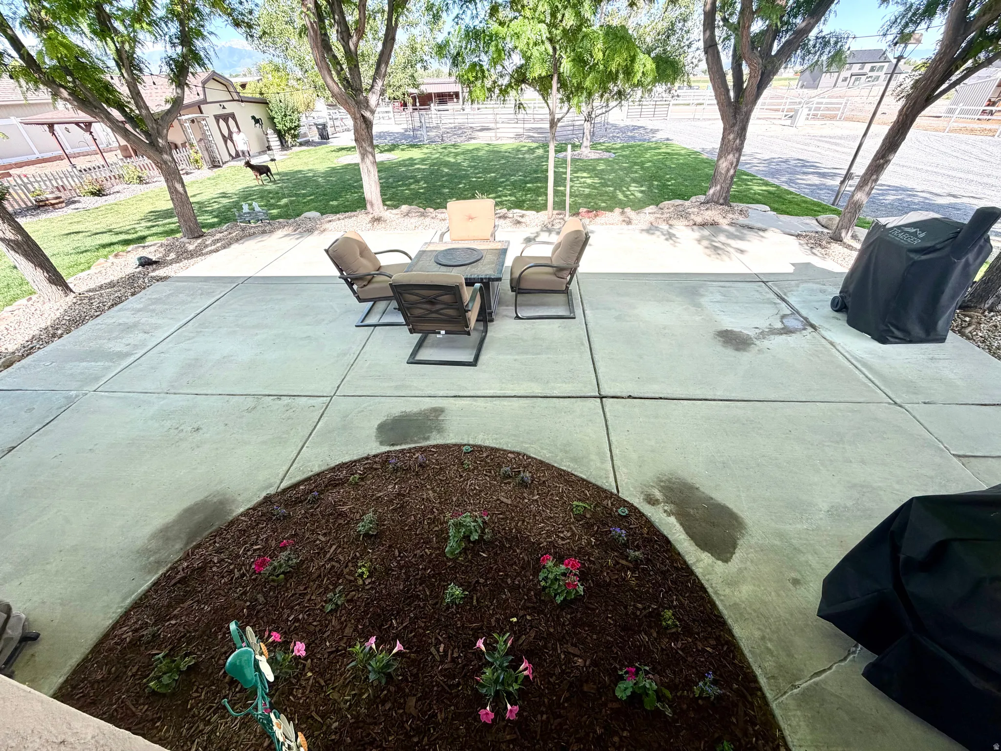 Expansive concrete patio with a landscaped planting bed