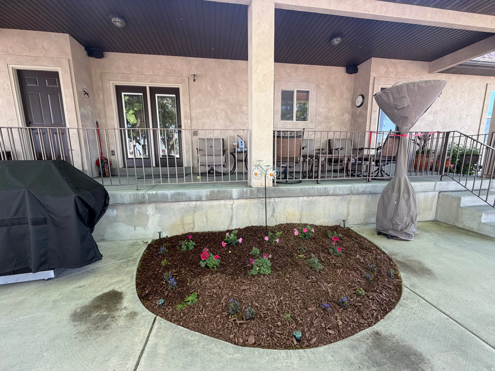 Exterior patio area featuring textured stucco walls and a dark brown soffit