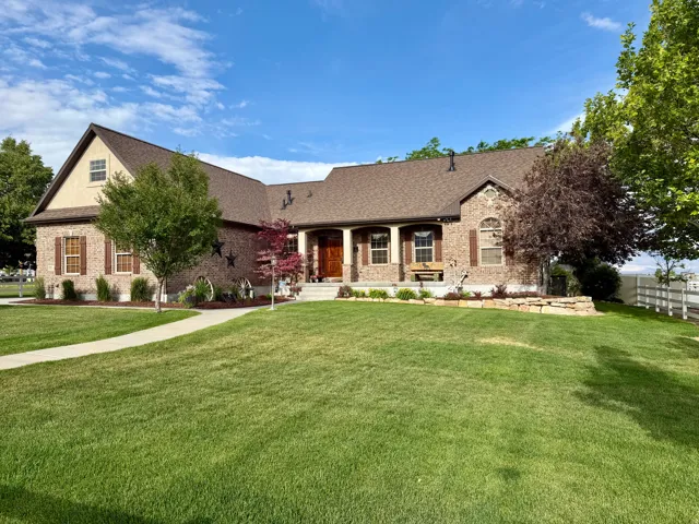 Brick and stucco exterior featuring a prominent gabled roofline and natural wood shutters