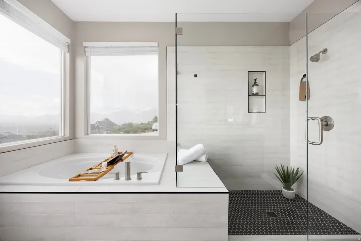 Expansive soaking tub with deck-mounted fixtures, set beneath multiple windows