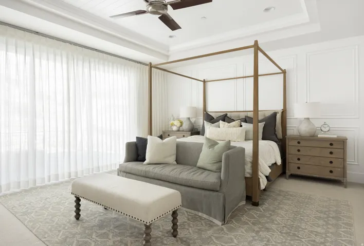 Spacious room featuring extensive wall paneling, a tray ceiling, and a ceiling fan