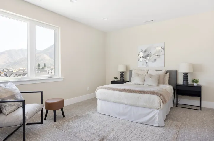 Bright room featuring a large window with mountain scenery, plush carpeting, recessed lighting, and a neutral color palette