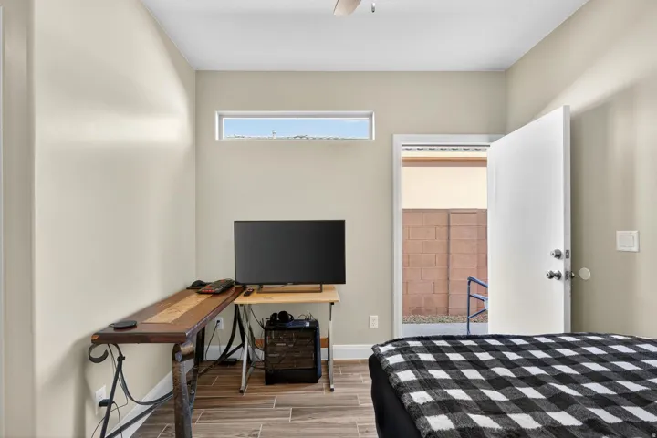 Room featuring wood-finish flooring, a transom window, and a white door with hardware