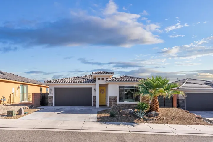 Contemporary stucco exterior with stone accents and a tiled roof