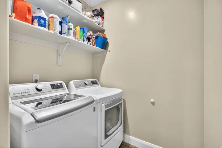 Dedicated laundry area featuring a top-load washer and front-load dryer with integrated controls